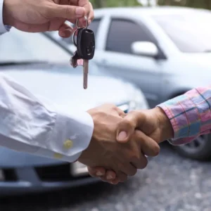 compro tu auto en cualquier estado zona norte: Apretón de manos cerrando la venta de un auto usado mientras se entregan las llaves, simbolizando un acuerdo rápido y seguro.
